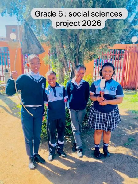 Four Grade 5 learners in school uniform with their social sciences project