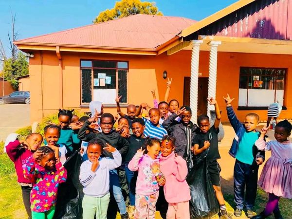 A group of learners posing happily outside the school building
