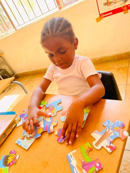 A young learner putting together a jigsaw puzzle